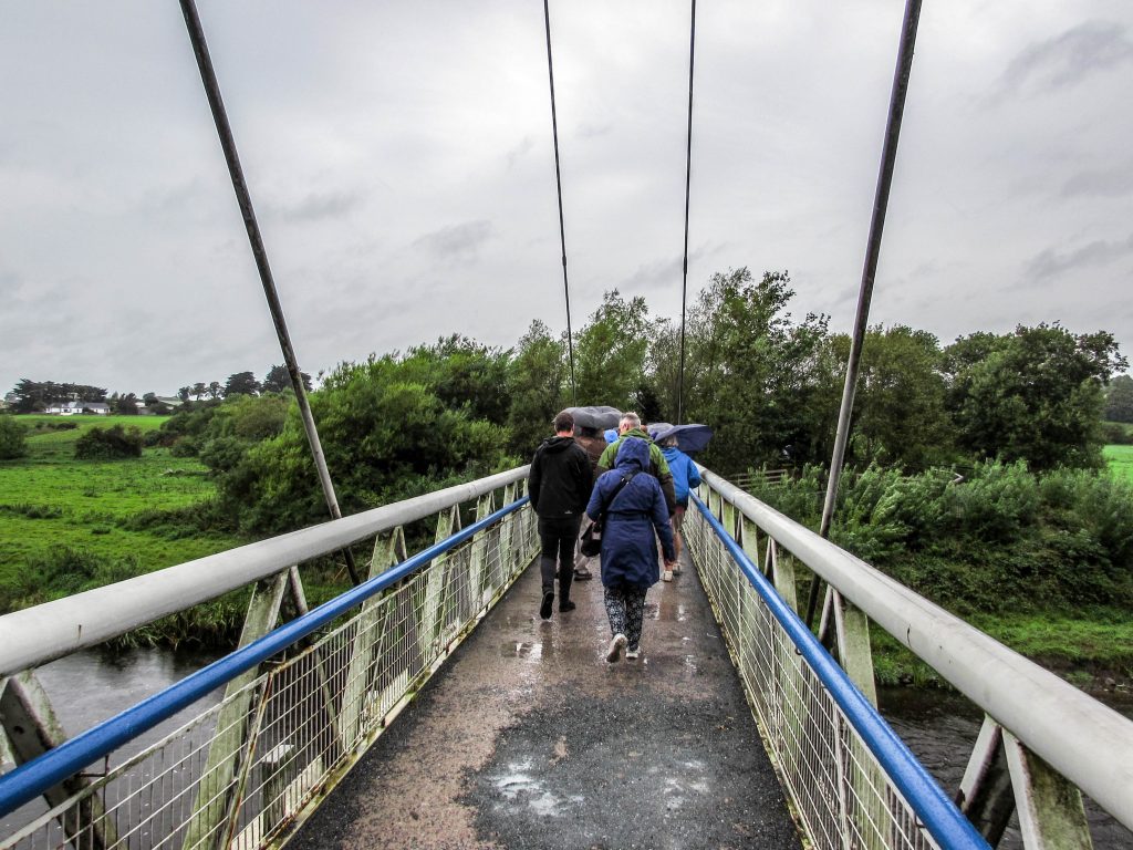 Photo showing people walking over the Boyne River on a rainy day. Towards Newgrange.